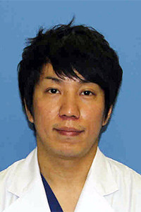 医療白衣を着た男性のポートレート。背景は青色で、福島県立医科大学のスタッフ紹介用の写真。