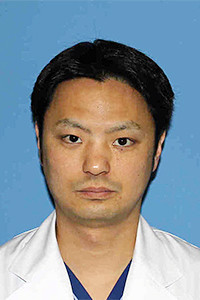 山内直人医師のプロフィール写真。白衣を着た男性が青い背景の前で真剣な表情をしています。