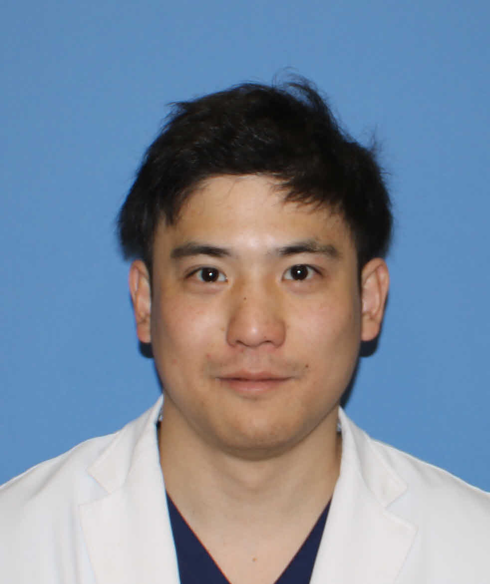 光井大助手のプロフィール写真。白衣を着て、青い背景の前で微笑んでいる。