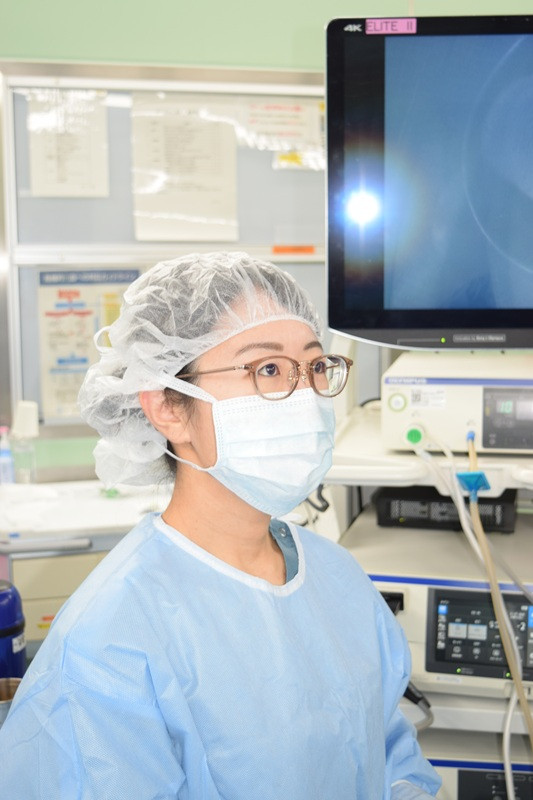 手術室でマスクとキャップを着用した医師が、手術に集中している様子。