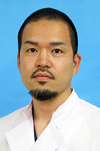 福島県立医科大学の学内講師、千田峻氏のポートレート。白衣を着用し、真剣な表情でカメラを見つめている。