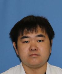 医療従事者の佐藤孝洋さんのプロフィール写真。白衣を着用し、青い背景の前で微笑んでいる。