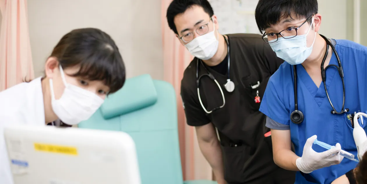 医療現場で患者のデータを確認する医師たちの様子。