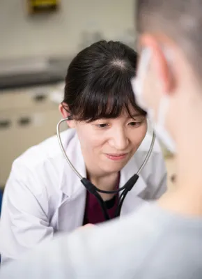 医師が聴診器を使って患者の健康状態を確認している様子。