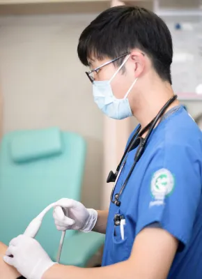 医療現場で超音波検査を行う医学生が、患者に向き合っている様子。