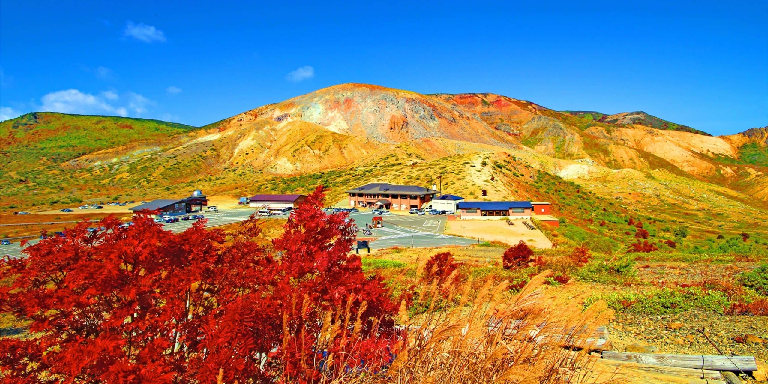 紅葉が美しい山々と青空の下に広がる福島県立医科大学のキャンパス風景。
