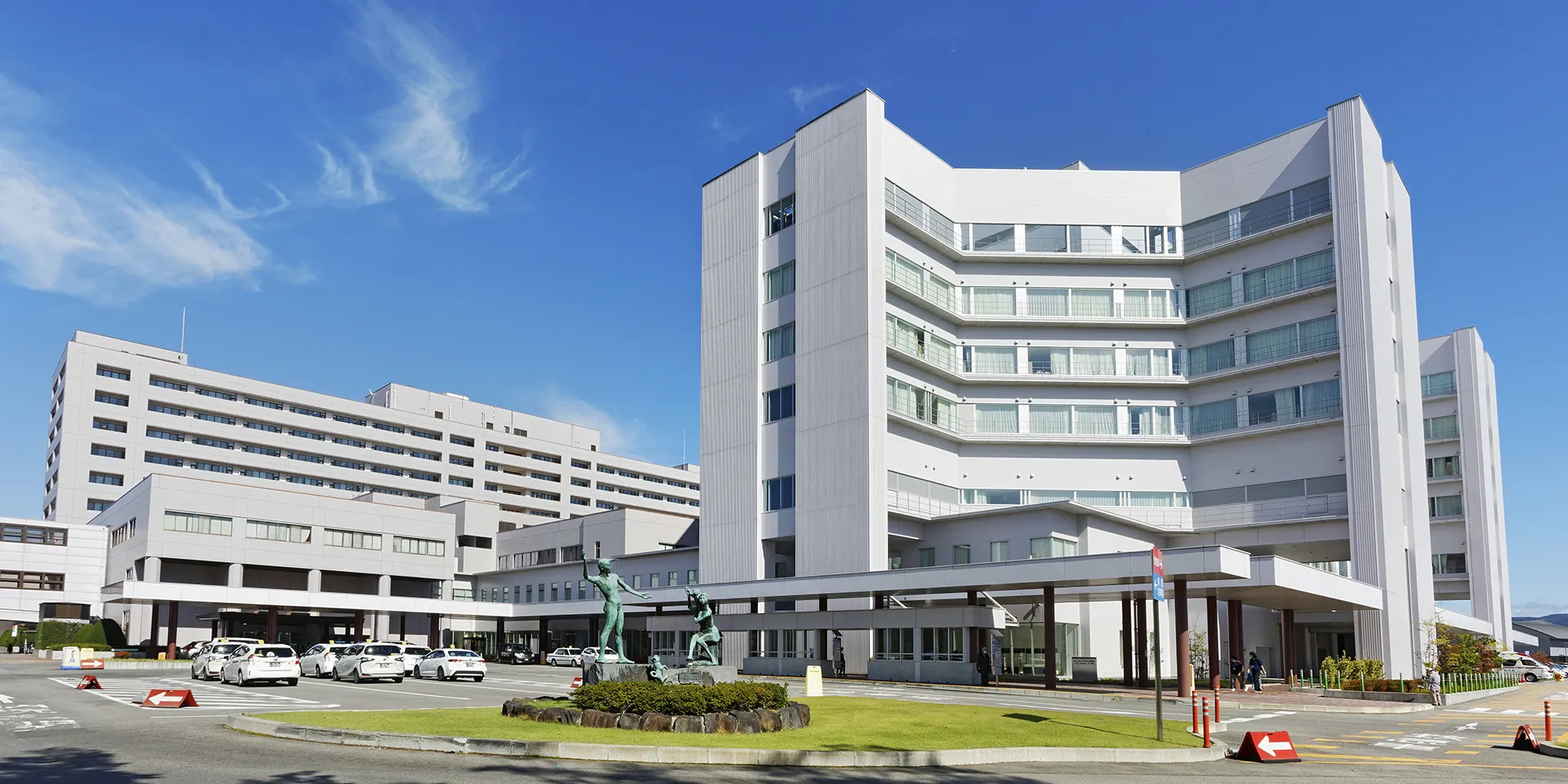 福島県立医科大学のキャンパス外観、白い建物と青空が広がる風景。
