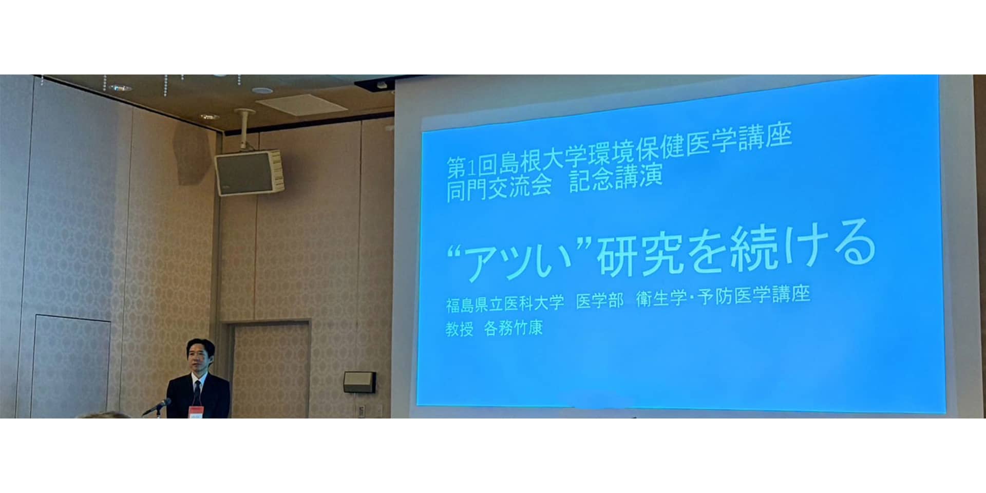 福島県立医科大学の全景、周囲には住宅地や駐車場、運動場が広がる。