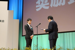 杉本充先生が日本内科学会奨励賞を受賞し、表彰式で表彰されている様子。