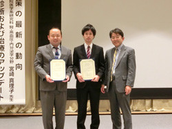 第214回日本内科学会東北地方会で受賞した滝口善規先生と郡司直彦先生が表彰状を持ってポーズをとる様子。