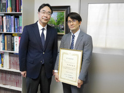 阿部和道先生が平成30年度日本肝臓学会研究奨励賞を受賞し、賞状を持っている写真。