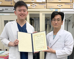 木村友哉先生が第17回日本消化管学会で優秀演題賞を受賞し、賞状を持つ姿。