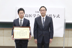 福島県立医科大学での受賞式の様子。表彰状を持つ受賞者と共に立つ大学関係者。