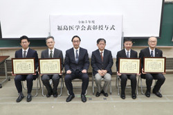 福島県立医科大学の卒業式で、受賞者たちが表彰状を持って並んでいる様子。