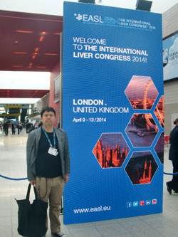 EASL 2014国際肝臓学会の看板の前に立つ男性の写真。ロンドンで開催された学会の参加を示す。