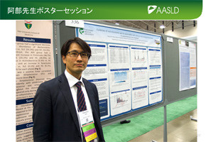 第68回米国肝臓学会でポスターセッションに参加している男性の姿。背景には研究成果が掲示されたポスターが並んでいる。