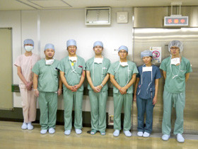 医療現場で働く医師たちが手術着を着て並んでいる様子。
