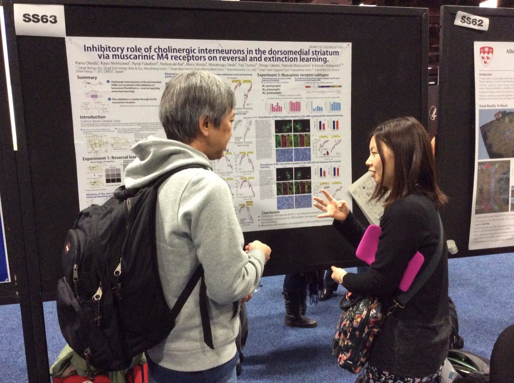 西澤博士のポスターを前にして話をしている様子。