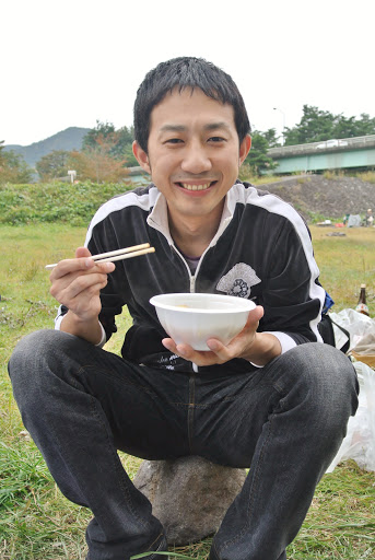 片手に器を持った男性が笑っている様子。