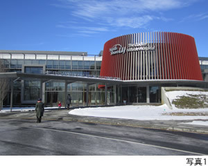 Zucker Hillside Hospitalの外観、赤い円形の構造物と雪の積もった地面が見える。