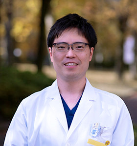 医療スタッフのイラスト。笑顔の男性が白衣を着ている。