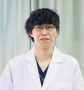 星総合病院勤務、菊田春彦さんが白衣を着て微笑んでいる写真。