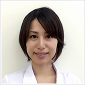 腫瘍内科医の木村礼子助教が白衣を着て微笑んでいるポートレート。