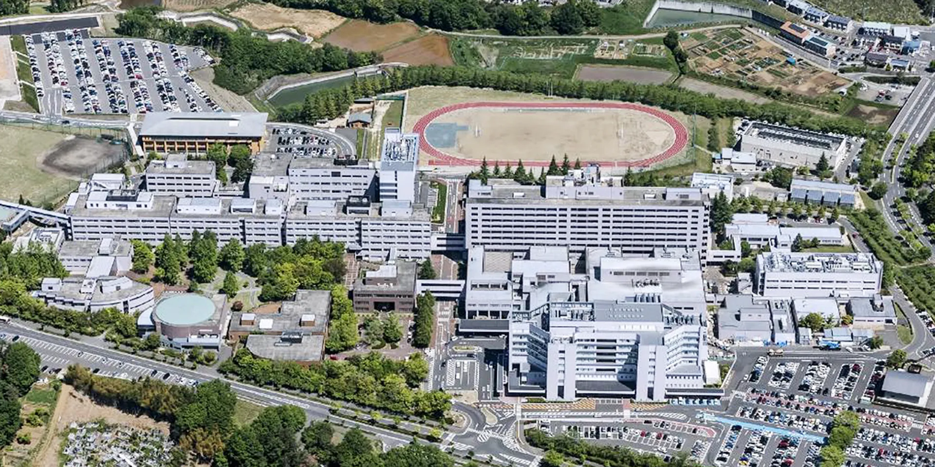 福島県立医科大学のキャンパス全景、駐車場や運動場が見える。