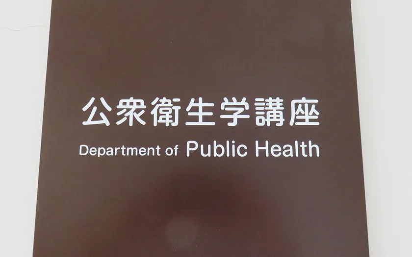 公衆衛生学講座の看板が写っている画像。白い文字で「公衆衛生学講座」と「Department of Public Health」と記載されている。