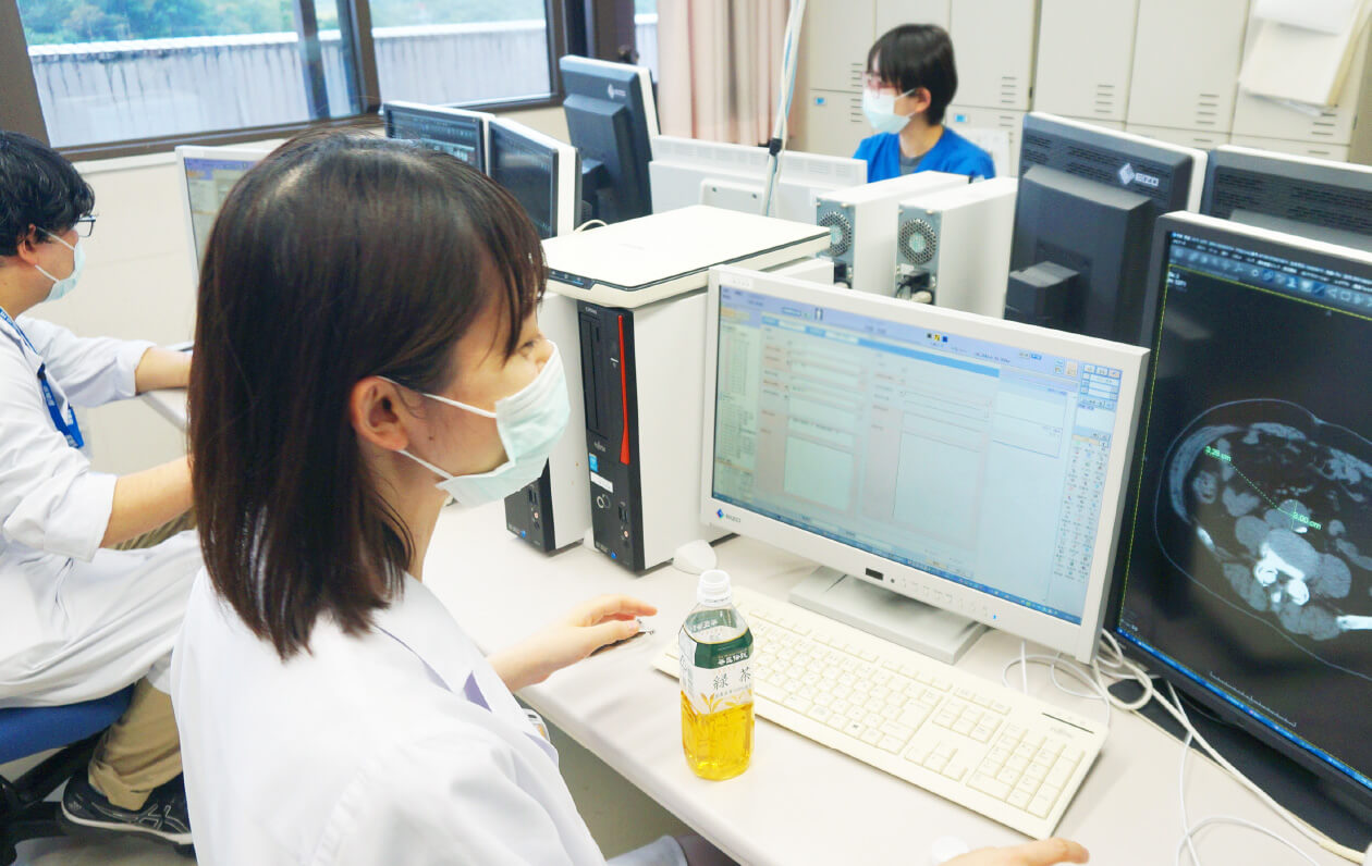 医学生がコンピュータの前で作業し、医療データを分析している様子。