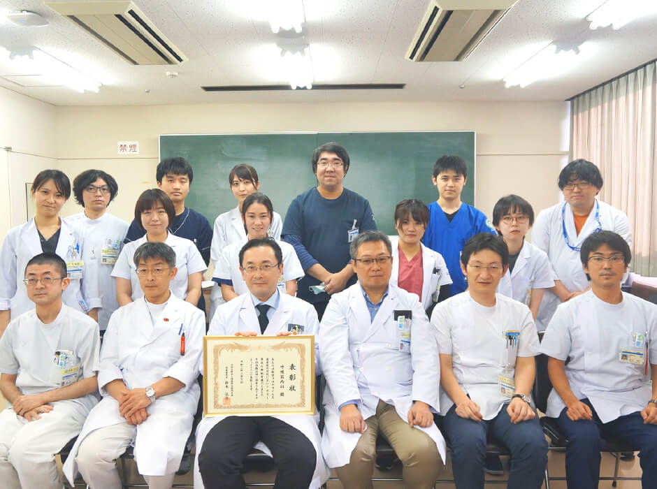 福島県立医科大学の呼吸器内科学講座の医師と学生たちが集合し、表彰状を持っている写真。