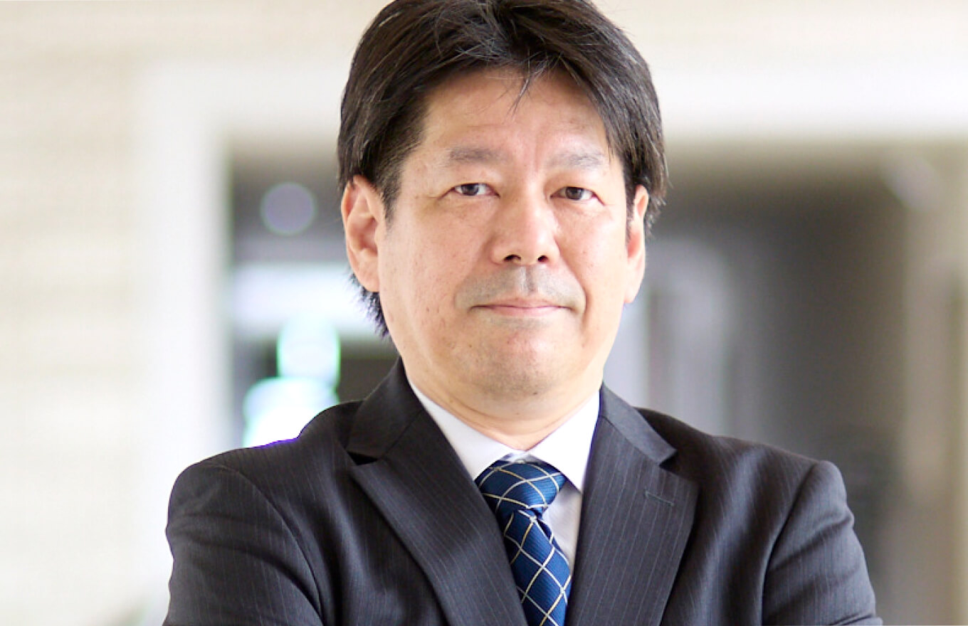 福島県立医科大学の放射線腫瘍学講座の教授がスーツを着て真剣な表情で立っている。