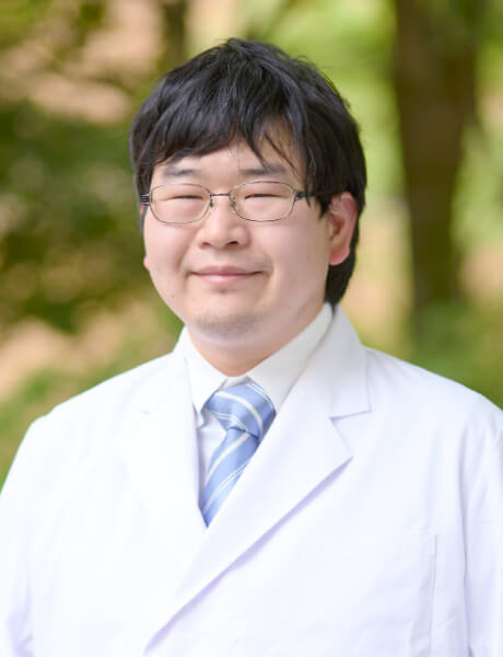放射線腫瘍学を専門とする伊藤佑輔医師の笑顔のポートレート。