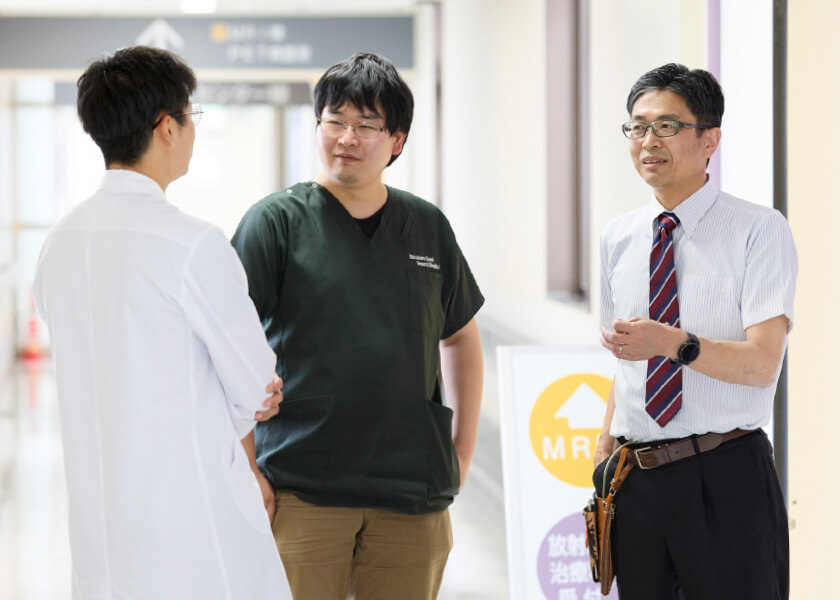 医学生と研修生が病院の廊下で話し合っている様子。