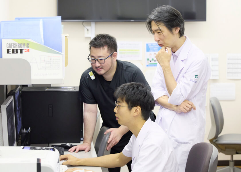 医学生と研修生がコンピュータの画面を見ながら議論している様子。