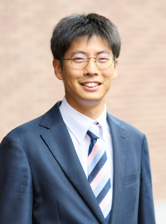 福島県立医科大学の病院助手、梅宮和真さんの笑顔のポートレート。