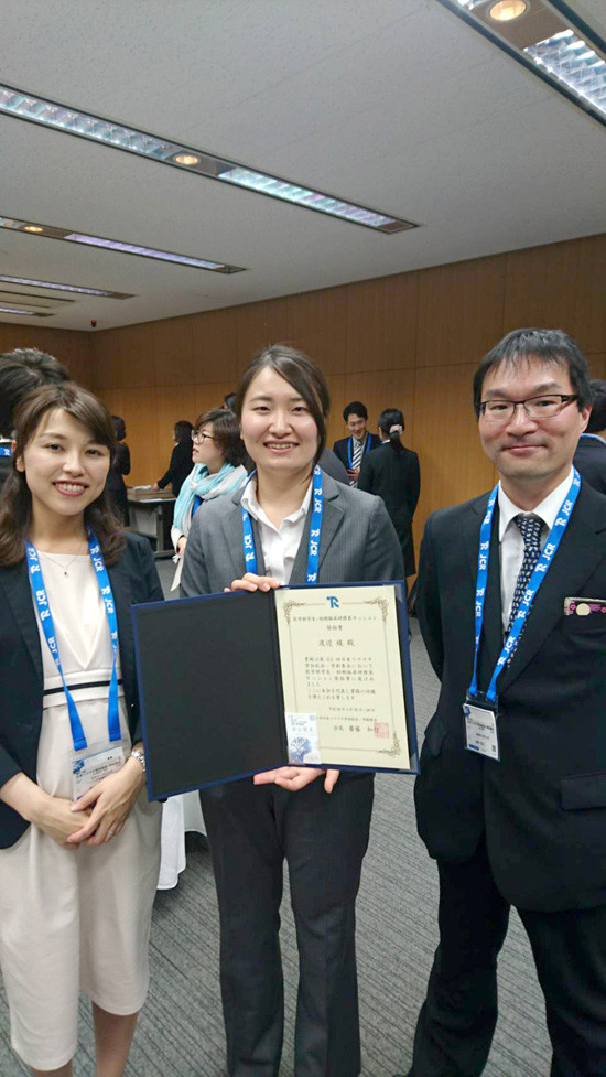 第62回日本リウマチ学会で奨励賞を受賞した渡辺綾先生が、賞状を持って笑顔でポーズをとる様子。