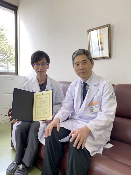 松本聖生先生がJCR2021国際ワークショップ優秀演題賞を受賞し、賞状を持っている写真。