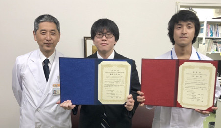 齋藤賢司先生と天目純平先生が受賞証書を持ち、笑顔で並んでいる写真。