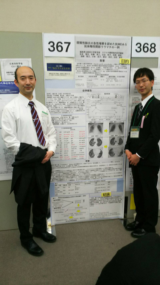 学会で症例発表を行う松本聖生先生と指導医の佐藤先生が、ポスターの前で笑顔で立っている様子。
