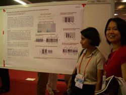 研究発表のポスターの前に立つ二人の女性。ポスターにはグラフやデータが示されている。