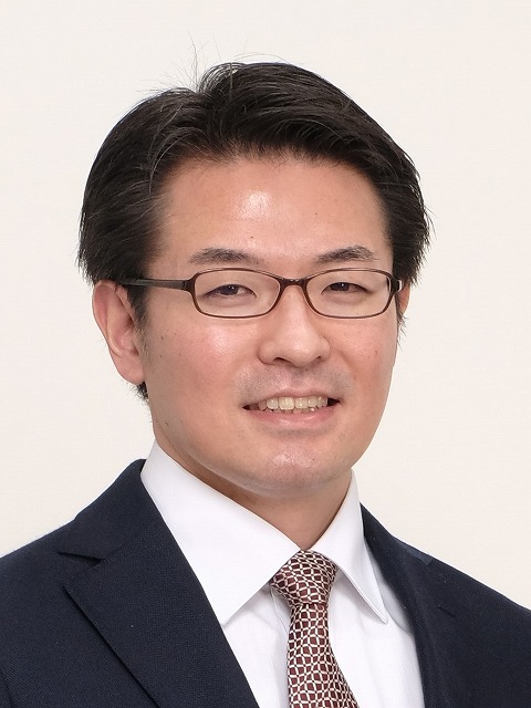 福島県立医科大学の講座に関連する男性のポートレート写真。ビジネススーツを着用し、真剣な表情でカメラを見つめている。