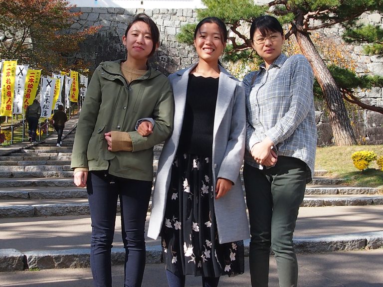 福島県立医科大学のキャンパスで、友人たちが笑顔で並んでいる写真。