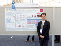 Best of Posters賞を受賞した研究パネル前の石橋啓氏。