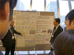 研究パネルの前にて。