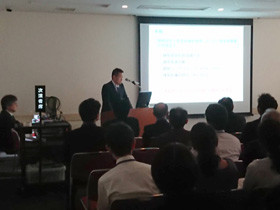 スーツを着た男性がプレゼンテーションを行っている様子。