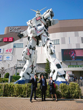 ダイバーシティの前に立つ巨大なロボット像と記念撮影する様子