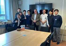 仲良くポーズをとる9人のグループ。