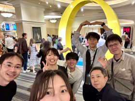 数人の男女がカメラに向かって笑顔でポーズをとっている様子。