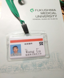 福島県立医科大学の名札とガイドブックが映っている画像。